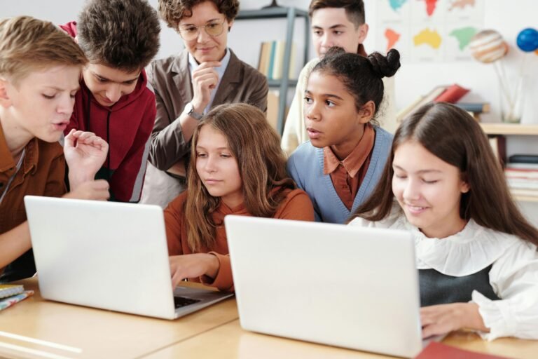 Teacher with students working on laptops