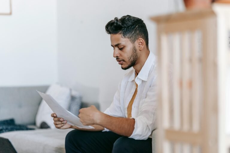 Young man staring at papers.