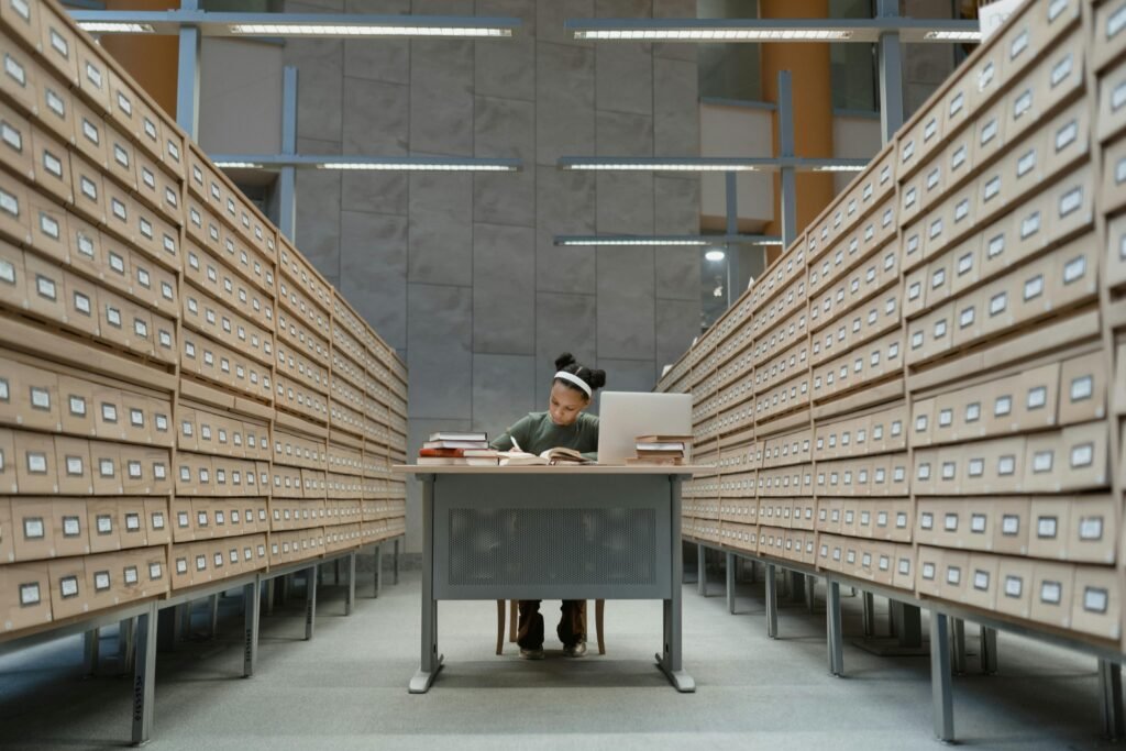 Person sitting in room with many file cabinets full of student information.