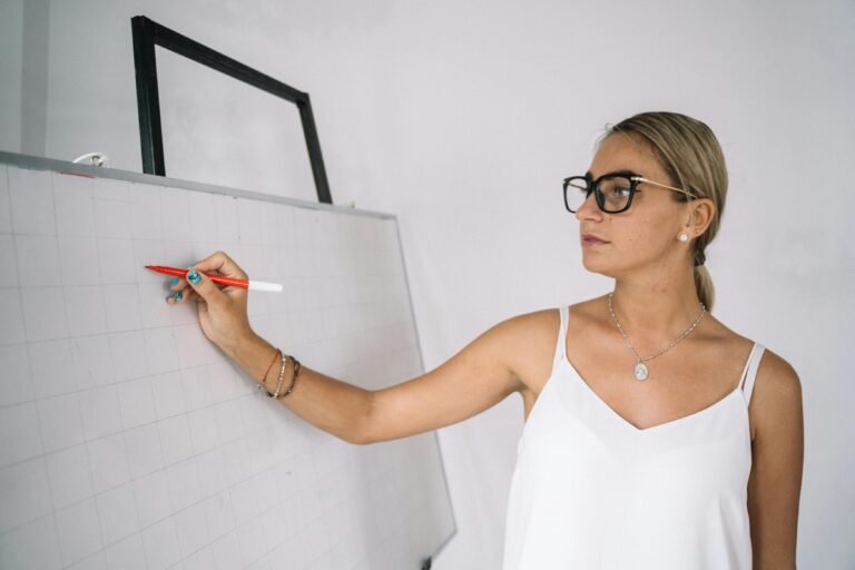 A female teacher writing on a white board