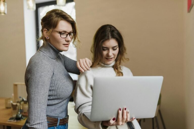 One person helping another with their computer.