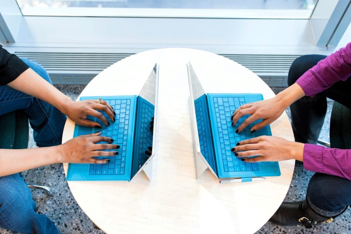 Two women working on a pair of matching laptops