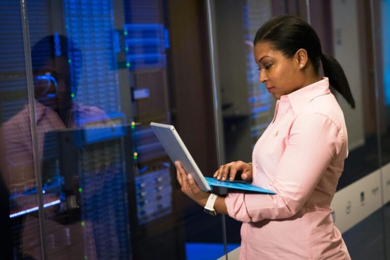 School technology staff holding a laptop.