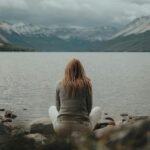 Person in deep reflection while looking into the lake trying to determine if a school is the right fit for them.