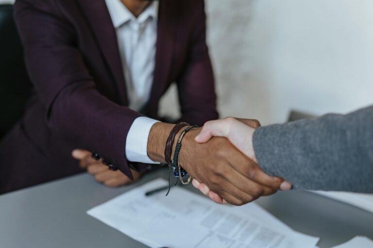 People shaking hands at the end of an interview for a school job.