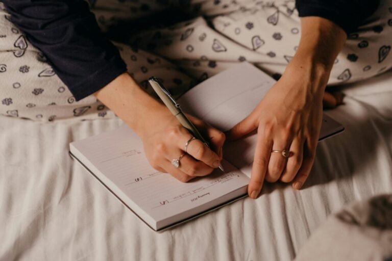 Woman writing notes in her journal after self-reflection.