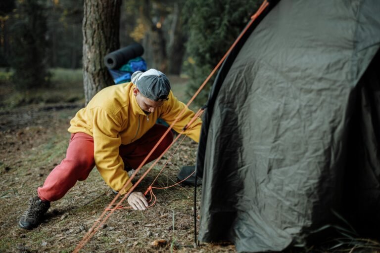 Summer camp counselor pitching a tent.