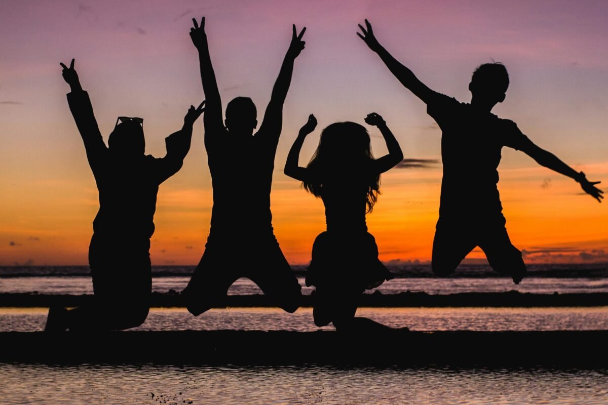 Counselor in training jumping in the air with other summer campers.