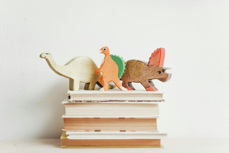 Dinosaur cut outs on top of pile of books.