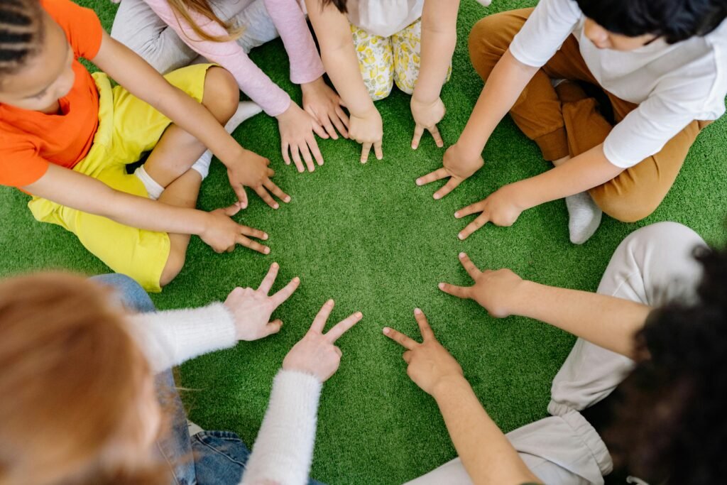 Group of kids on mat listing as a book on feelings is read.