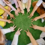 Group of kids on mat listing as a book on feelings is read.